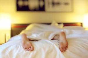 les pieds d'une personne endormie sortent des draps